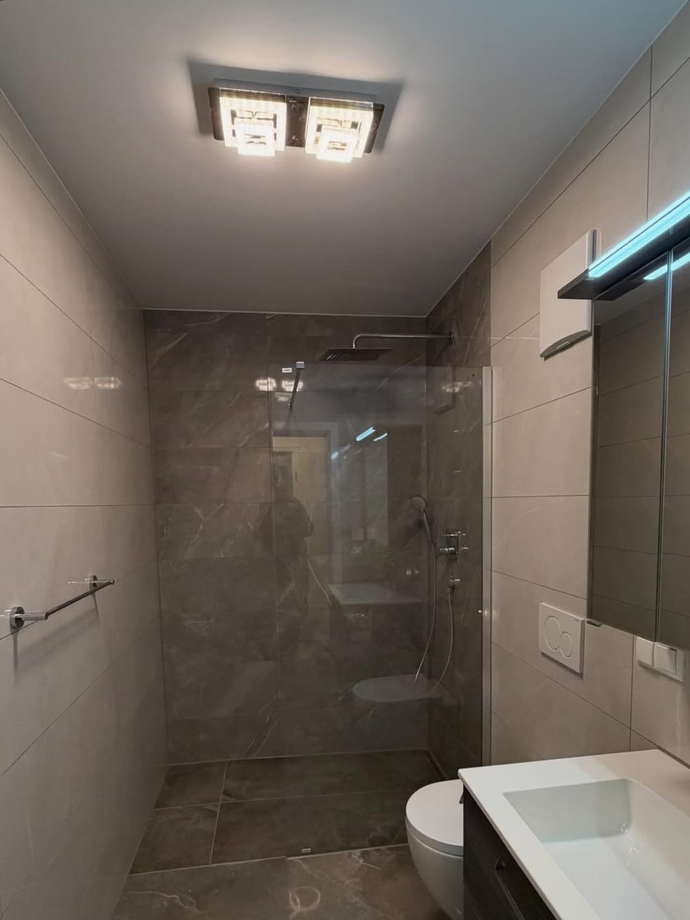 Bad in Marmoroptik mit ebenerdiger Walk-in-Dusche
