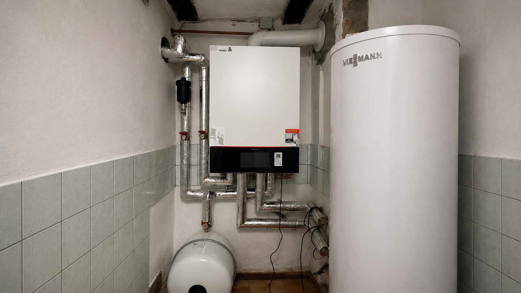 Fachgerecht installierte Viessmann Gas-Brennwerttherme mit Warmwasserspeicher und sauber gedämmter Verrohrung im Heizungsraum